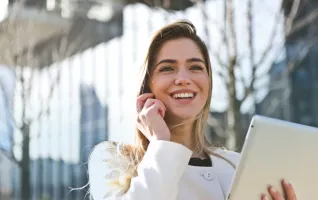 Frau-weißer-Blazer-hält-Tabletcomputer-redet-Telefon
