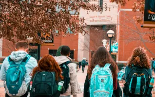 group of students walking towards a private university entrance