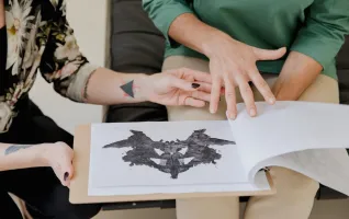 Psychologe in der Praxis zeigt einem Patienten einen Rorschach-Test