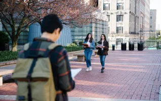 Studenten, die mit Büchern über den Campus laufen