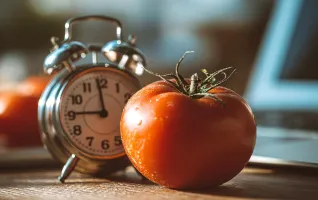 Tomate und Wecker versinnbildlichen die Pomodoro-Technik als Lernmethode