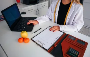 Mitarbeiter im Gesundheitswesen mit Laptop und Notizblock