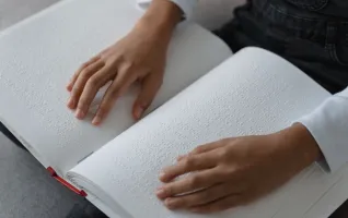 Person, die ein Blindenbuch liest