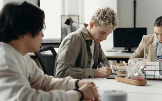 A diverse group of young professionals brainstorming in a contemporary office environment.