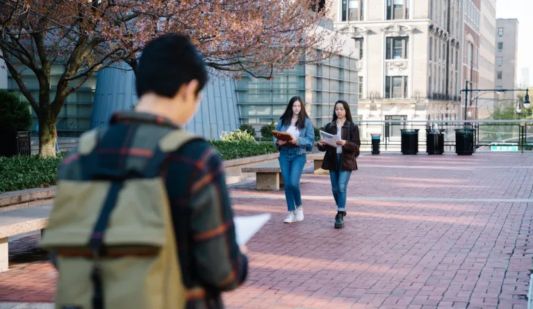 Studenten, die mit Büchern über den Campus laufen